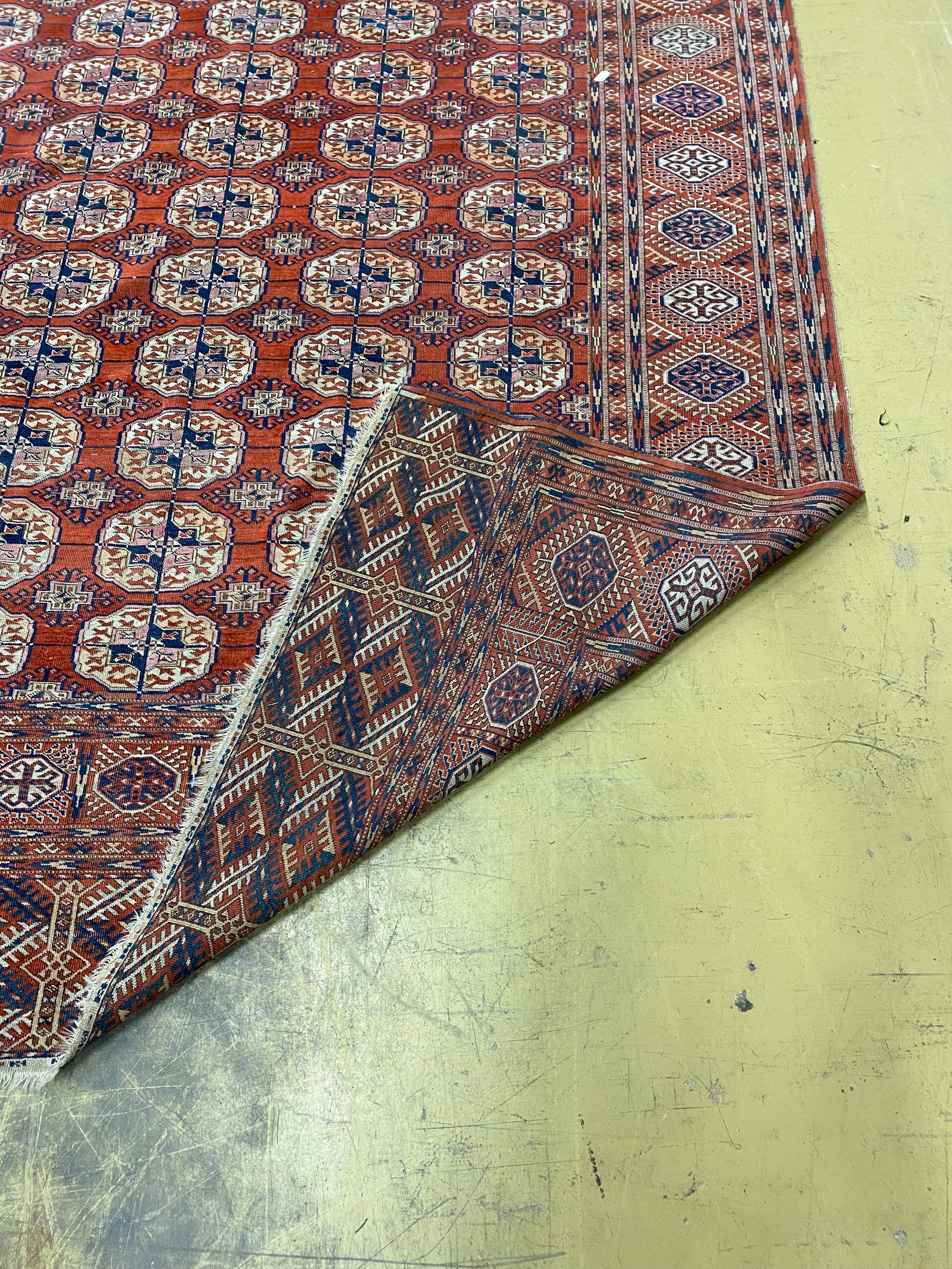 A Bokhara brick red ground carpet, 350 x 230cm